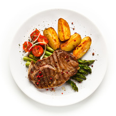 Grilled beef steaks,chips and asparagus on white background