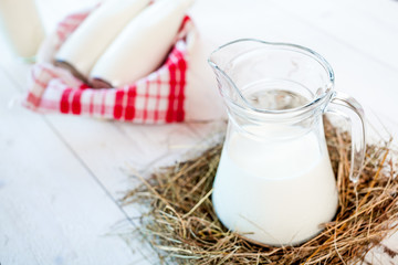 jug of milk and glasses of milk on a wooden rustic table.
