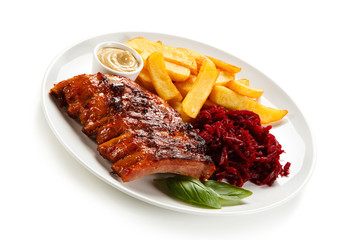 Grilled ribs, French fries and vegetables on white background