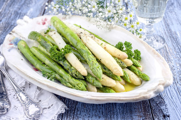 Boiled green and white asparagus as top view on a plate