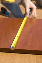 Pomiar odległości deski miarką. © Tomasz
