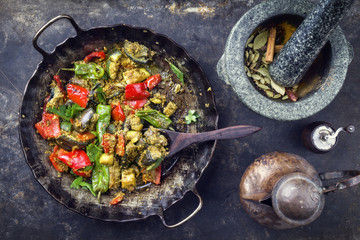Indian vegetable curry fry with eggplant and sweet peppers as close-up in a in a frying pan