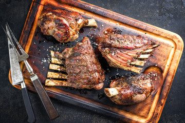 Barbecue Leg of Lamb and Veal Loin as top view on burnt cutting board