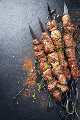 Traditional Russian shashlik on a barbecue skewer as top view on a board