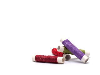 Thread tube (Dark red, red, green, purple) on white background