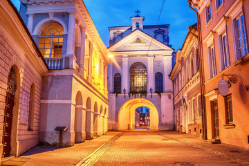 Vilnius, Lithuania: the Gate of Dawn, Lithuanian Ausros, Medininku vartai, Polish Ostra Brama, a city gate of Vilnius, one of its most important historical, cultural and religious monuments in sunrise - obrazy, fototapety, plakaty