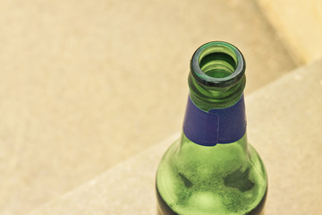 Bottle of beer resting on the ground - image with copy space