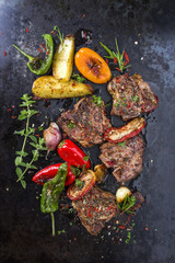 Barbecue T-bone Lamm Steak mit Gemüse und Kräuter als Draufsicht auf alten Board