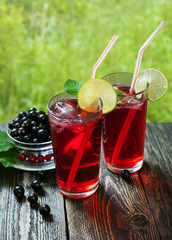 Cocktail of currant in tall glasses on a wooden table