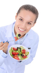 Portrait of a beautiful woman doctor holding a plate with fresh vegetables. Woman doctors.