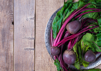 Group of beetroot on plate on wooden background, rustic