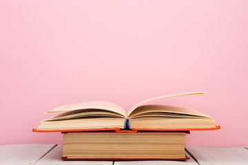 education and wisdom concept - open book on wooden table, color background