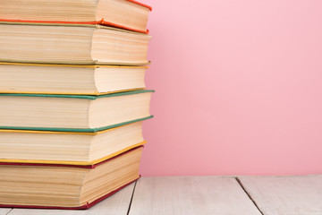 education and wisdom concept - open book on wooden table, color background