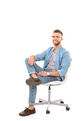 Young man sitting on the chair isolated over white background. Startupper. Young entrepreneur.