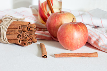 red apple and cinnamon on white table
