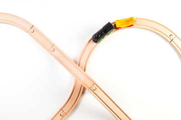 Toy train and wooden rails on white background. Top view.