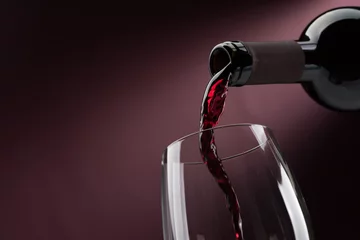 Photo sur Plexiglas Vin Verser du vin rouge dans un verre à vin