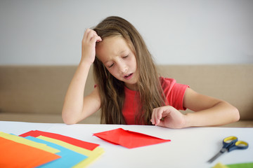 The girl puts origami from paper. lesson of origami