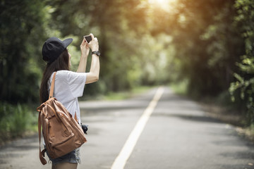 Fototapeta premium Outdoor summer smiling lifestyle portrait of pretty young woman having fun with camera travel photo of photographer Making pictures