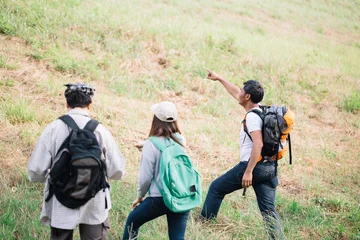 Tuinposter Group of backpacking hikers going to mountain top. Backpackers or Hikers travel concept. Selective focus. © chayantorn