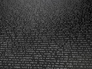 Finely written text on a black background. Abstract background. White on black.
