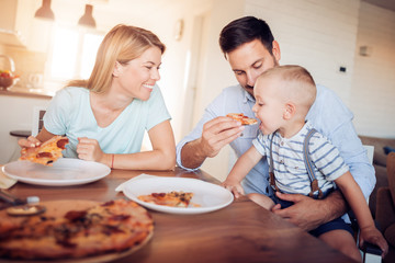 Obraz na płótnie Canvas Happy lovely family eating pizza