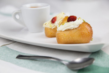 Neapolitan babà and coffee on white white dish