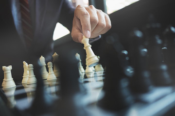 businessman playing chess on board in office, strategy and competition concept