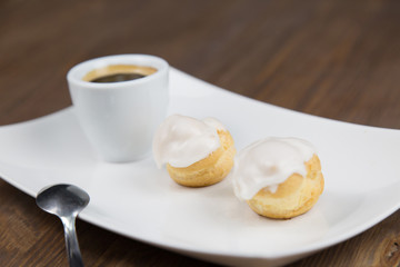 bignè and coffee on white dish