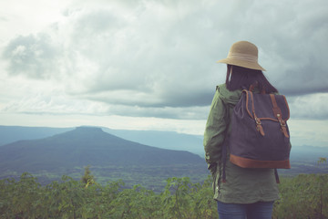 Hipster young woman with backpack enjoying. Tourist traveler on mountain background