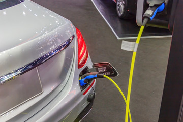 Power supply for electric car charging. Electric car charging station. Close up of the power supply plugged into an electric car being charged.