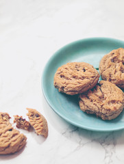 Crunchy chocolate chip cookies or biscuits on a decorative plate on marble background
