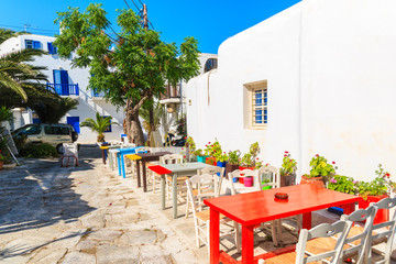 Colourful tables of a small bar on narrow street of Mykonos town, Mykonos island, Greece