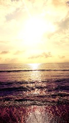 Die untergehende Sonne spiegelt sich im Meer 