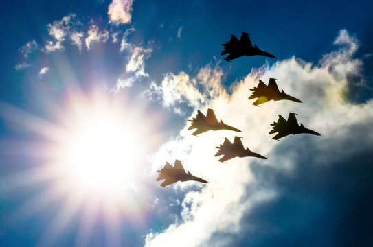Group of fighter jet airplane sun glow blue sky