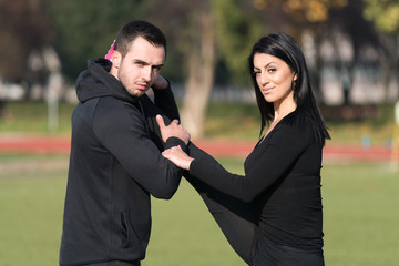 Sports Couple Stretching Body in the Park