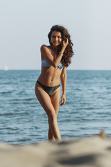 Obraz premium Hight fashion colors,Glamour Portrait of pretty beautiful fashion woman in bikini posing in summer near the sea and blue sky in sunshine,tropic island girl on vacation