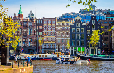 Traditional old buildings and and boats in Amsterdam, Netherlands. Canals of Amsterdam.