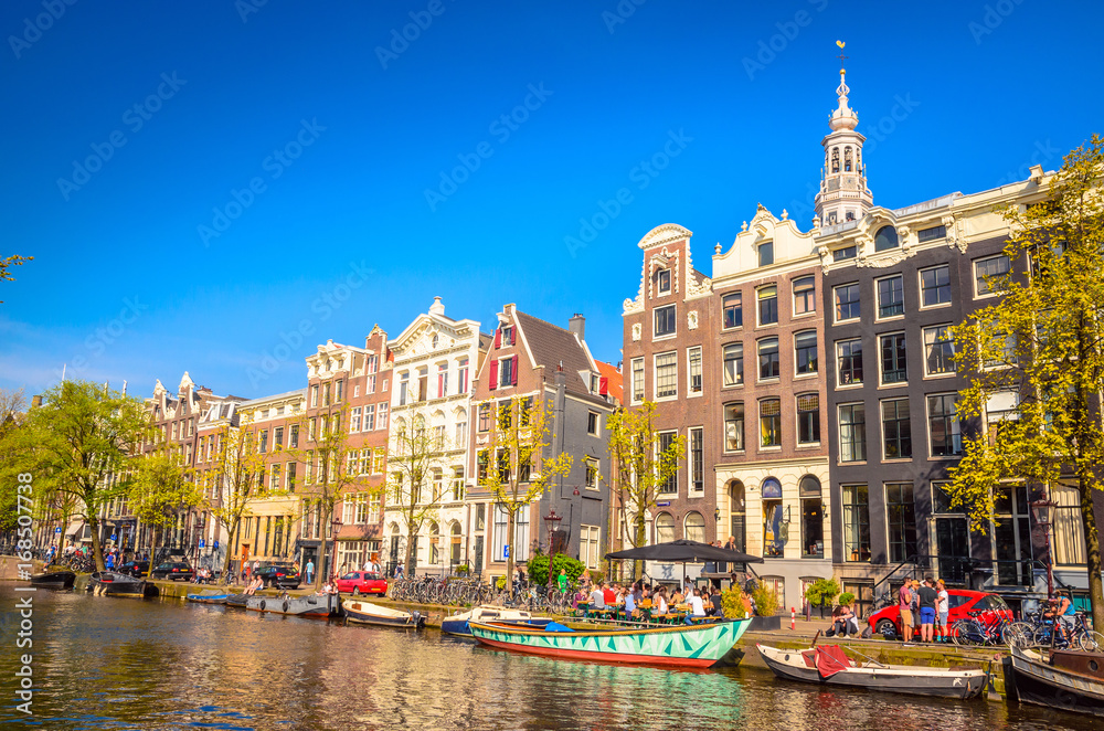 Wall mural Traditional old buildings and and boats in Amsterdam, Netherlands. Canals of Amsterdam.