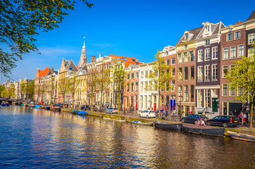 Naklejka premium Traditional old buildings and and boats in Amsterdam, Netherlands. Canals of Amsterdam.