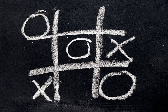 White chalk drawing as Tic Tac Toe with the winner and loser shape on black board background