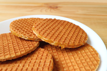 Plate of Stroopwafel Cookies, Tasty Dutch Traditional Sweets served on wooden table 
