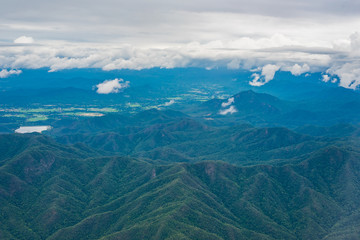 Fototapeta premium The cumulonimbus cloud formation and mountain terrain view from aircraft window