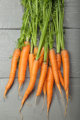 Fresh vegetables, carrots on a gray wooden background.