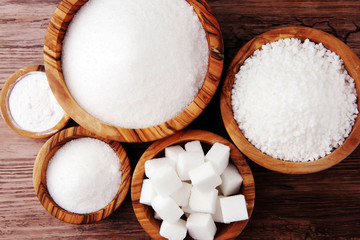 Sugar composition with white sugar in bowls on wooden board