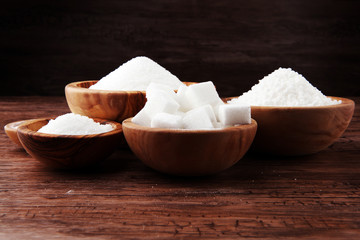 Sugar composition with white sugar in bowls on wooden board