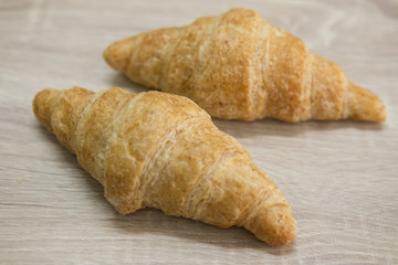 CROISSANT
Two brown croissant on the wood table.