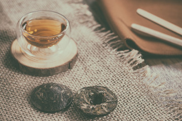 Cup of freshly brewed tea and Beads of Chinese Puer tea
