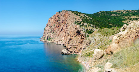Fototapeta na wymiar Rocky shore coast of tropical azure sea. The Black Sea, Crimea. Hot, sunny summer day