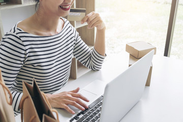 Happy Woman using smart phone and credit card register payments online shopping and customer service network connection market, using technology on laptop, Internet Online shopping or banking concept
